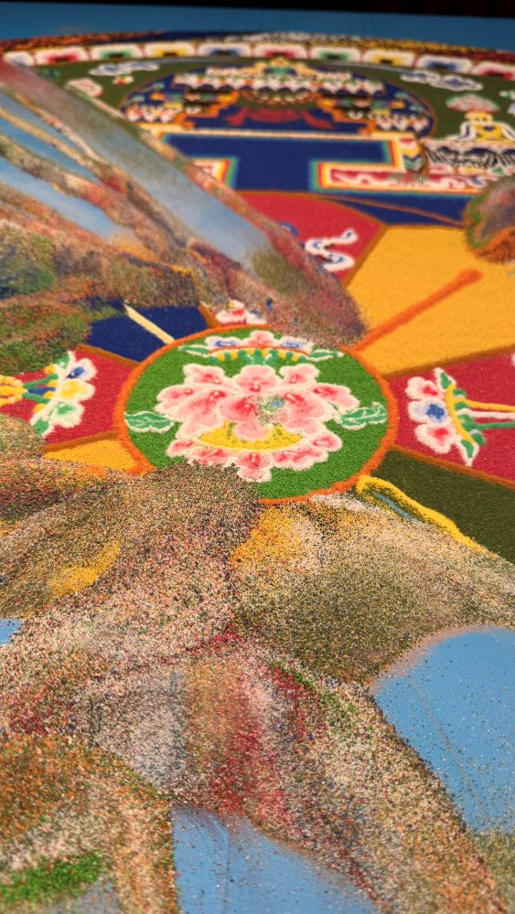 Das Sandmandala löst sich rund um die Lotusblüte auf. Das Sandmandala löst sich rund um die Lotusblüte auf.