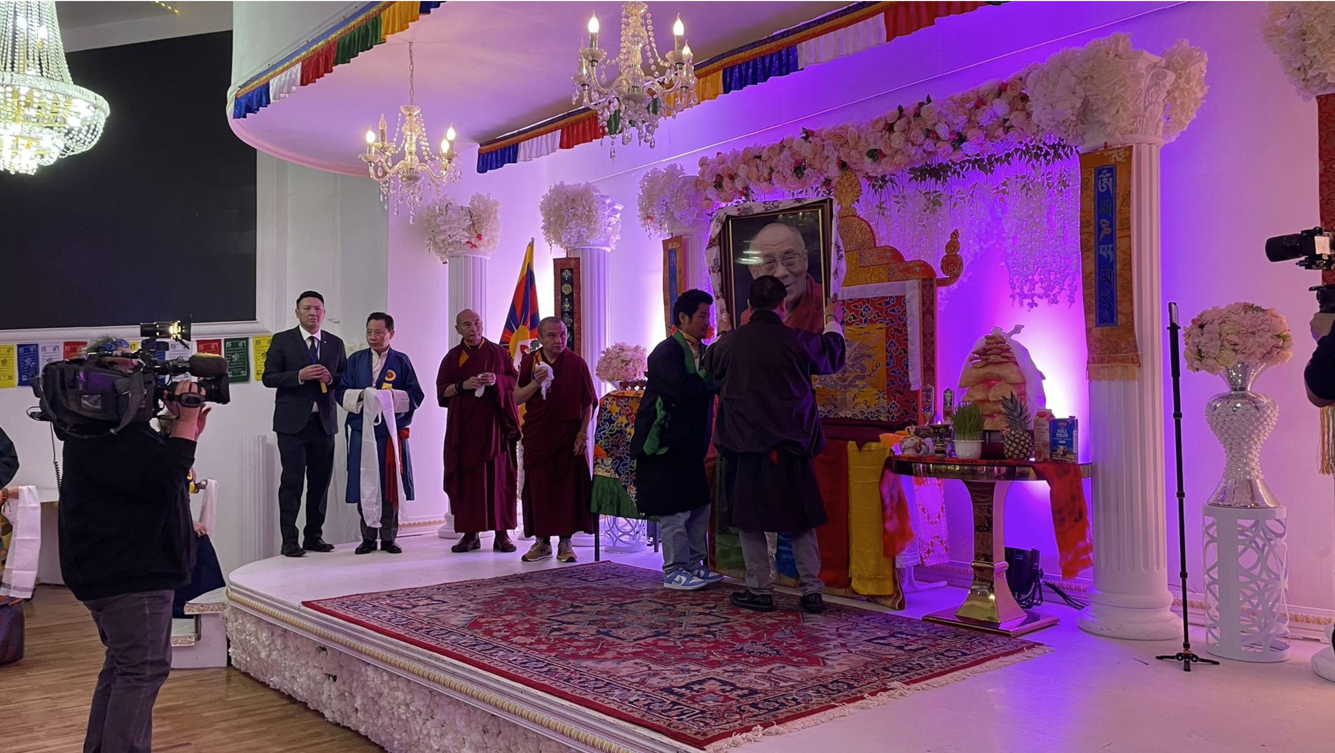 Das Foto Seiner Heiligkeit dem 14. Dalai Lama von Tibet wird am Altar positioniert